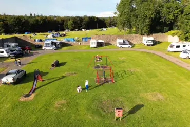 Aerial of the touring pitches and play park at Treborth Hall Farm Caravan Site