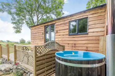 Stag lodge shepherd's hut with a wood-fired hot tub at Banwy Glamping