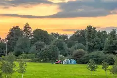 Non electric grass tent pitches at sunset Non electric grass tent pitches at sunset