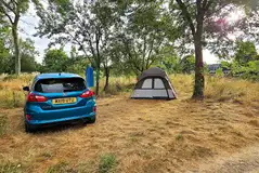 Small tent on a non electric grass pitch with space for a parked car