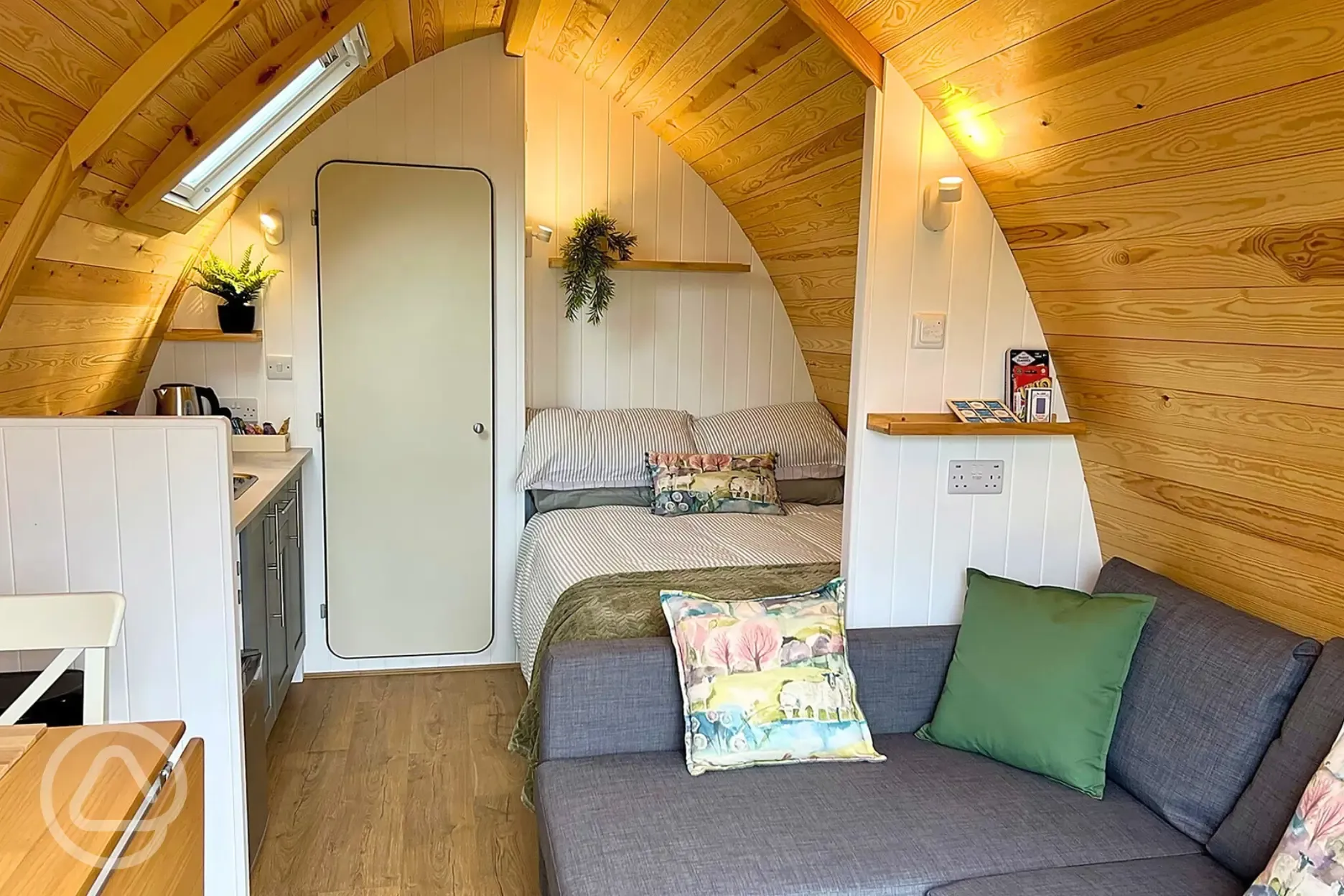 Glamping pod interior with a double bed, double sofa bed and kitchenette