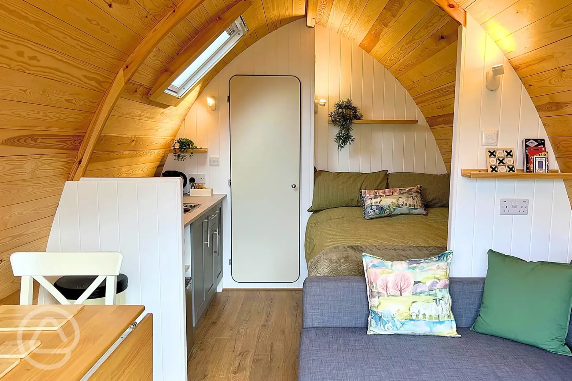 Glamping pod interior with a double bed, double sofa bed and kitchenette
