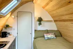 Glamping pod interior with a double bed with bedding provided