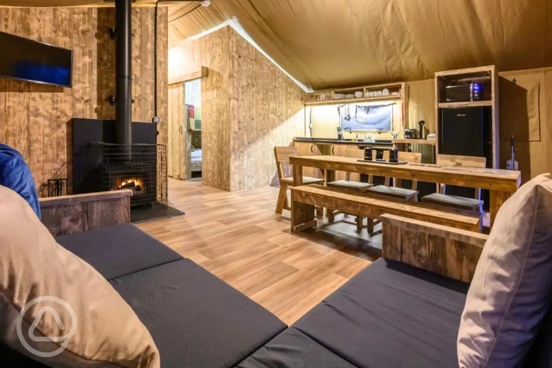 Large Deluxe Safari Tent with a sofa, TV, wood burner, kitchen and dining area