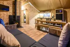 Large Deluxe Safari Tent with a sofa, TV, wood burner, kitchen and dining area
