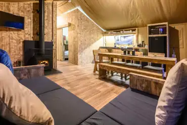 Large Deluxe Safari Tent with a sofa, TV, wood burner, kitchen and dining area