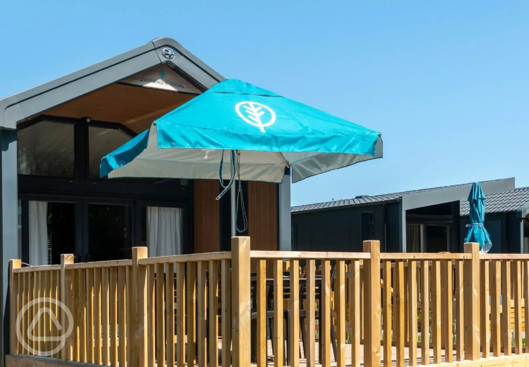 Superior glamping cabins with an outdoor deck, furniture and parasol