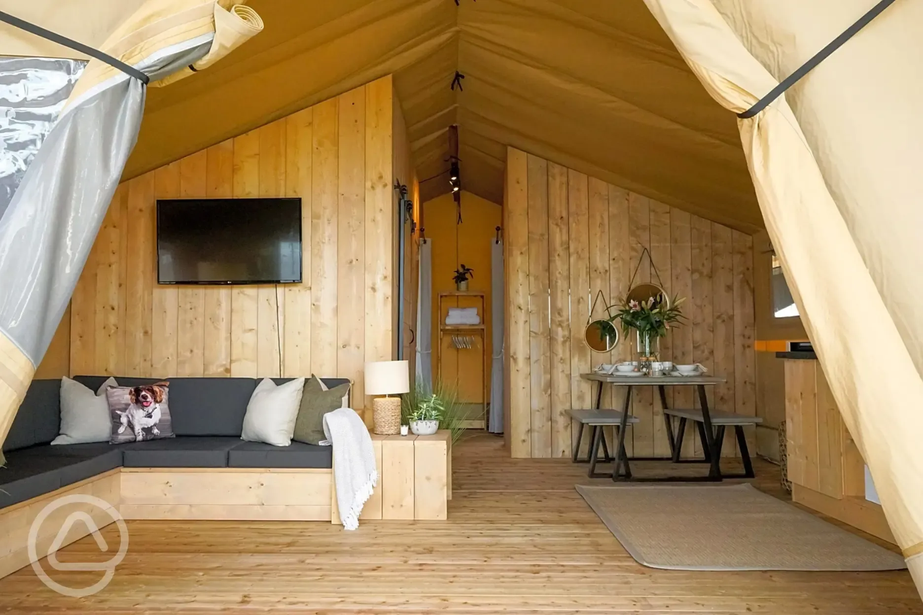 Deluxe safari tent with a sofa, TV, dining area and kitchen