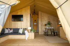 Deluxe safari tent with a sofa, TV, dining area and kitchen