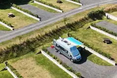 Aerial of hardstanding and grass pitches with small dividing walls between