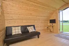 Camping pod with single sofa beds and a small TV