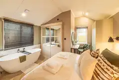 Snug cabin bedroom with a free-standing bath and ensuite bathroom Snug cabin bedroom with a free-standing bath and ensuite bathroom
