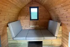 Camping pod with a seating area and table that converts to a double bed Camping pod with a seating area and table that converts to a double bed