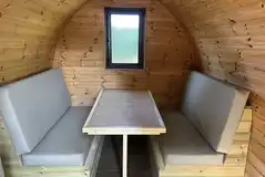 Camping pod with a seating area and table that converts to a double bed Camping pod with a seating area and table that converts to a double bed