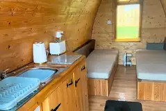 Camping pod with a double convertible dining bench and kitchenette Camping pod with a double convertible dining bench and kitchenette