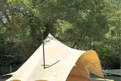 Bell tent on a wooden deck with a wood burner