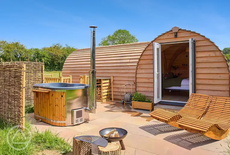 Coppice glamping pod with a wood-fired hot tub, fire pit and seating