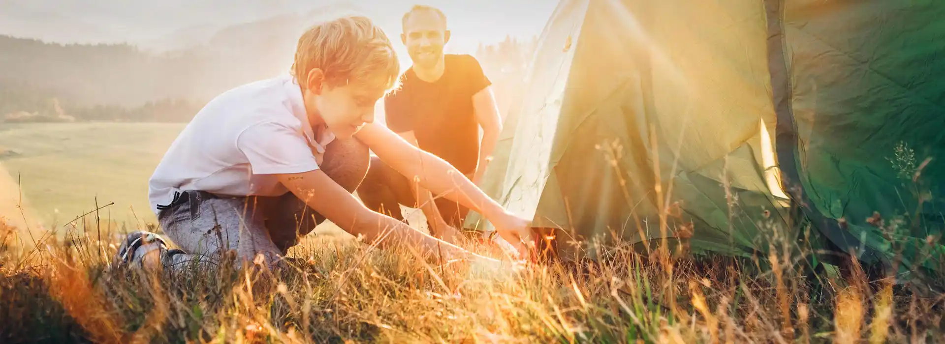 Father and son set up tent