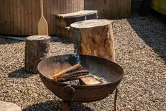 Fire pit area with wooden stool seating Fire pit area with wooden stool seating