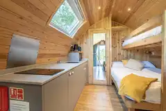 Five person pod kitchen with a sink, microwave, fridge and kettle 