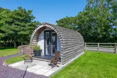 Clychau'r Gog glamping pod with outdoor furniture and a picnic area