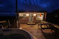 Woodland hut with hot tub at night
