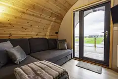 Mega glamping pod interior with a double sofa bed