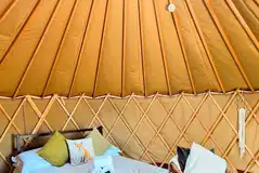 Yurt interior with double bed and seating