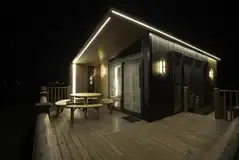 Glamping S-pod lit up at night
