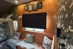 Converted horsebox living area with sofa seating and a log burner