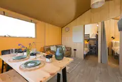 Safari tent kitchen and living area with a sofa and TV Safari tent kitchen and living area with a sofa and TV