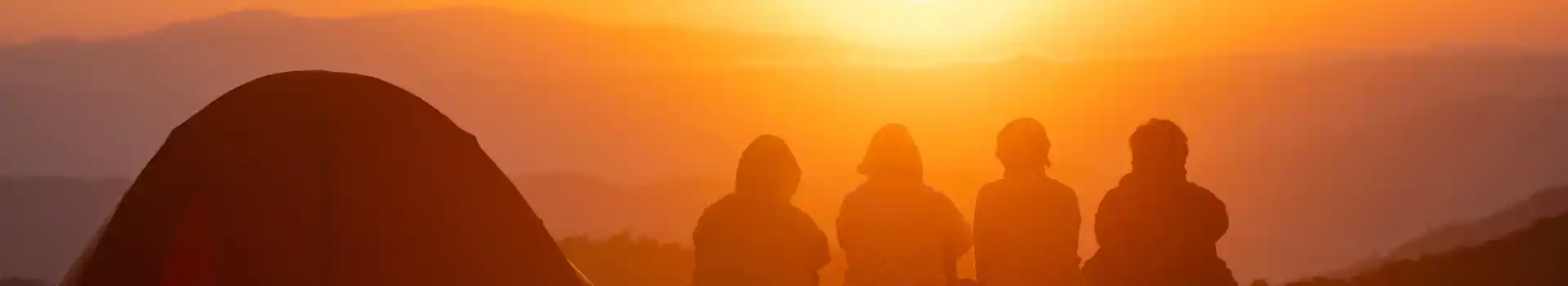 Group campers overlooking a sunset