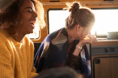 Two women laughing in a caravan